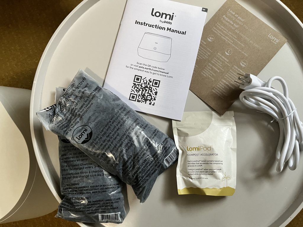 image of lomi charcoal refills, lomi pods, plug, and manuals