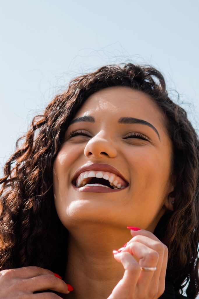 image of woman smiling with nice teeth for benefits of vitamin k blog post